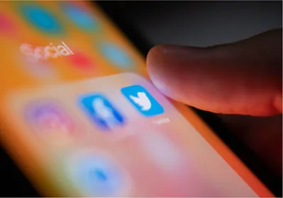 Smartphone with thumb over twitter icon